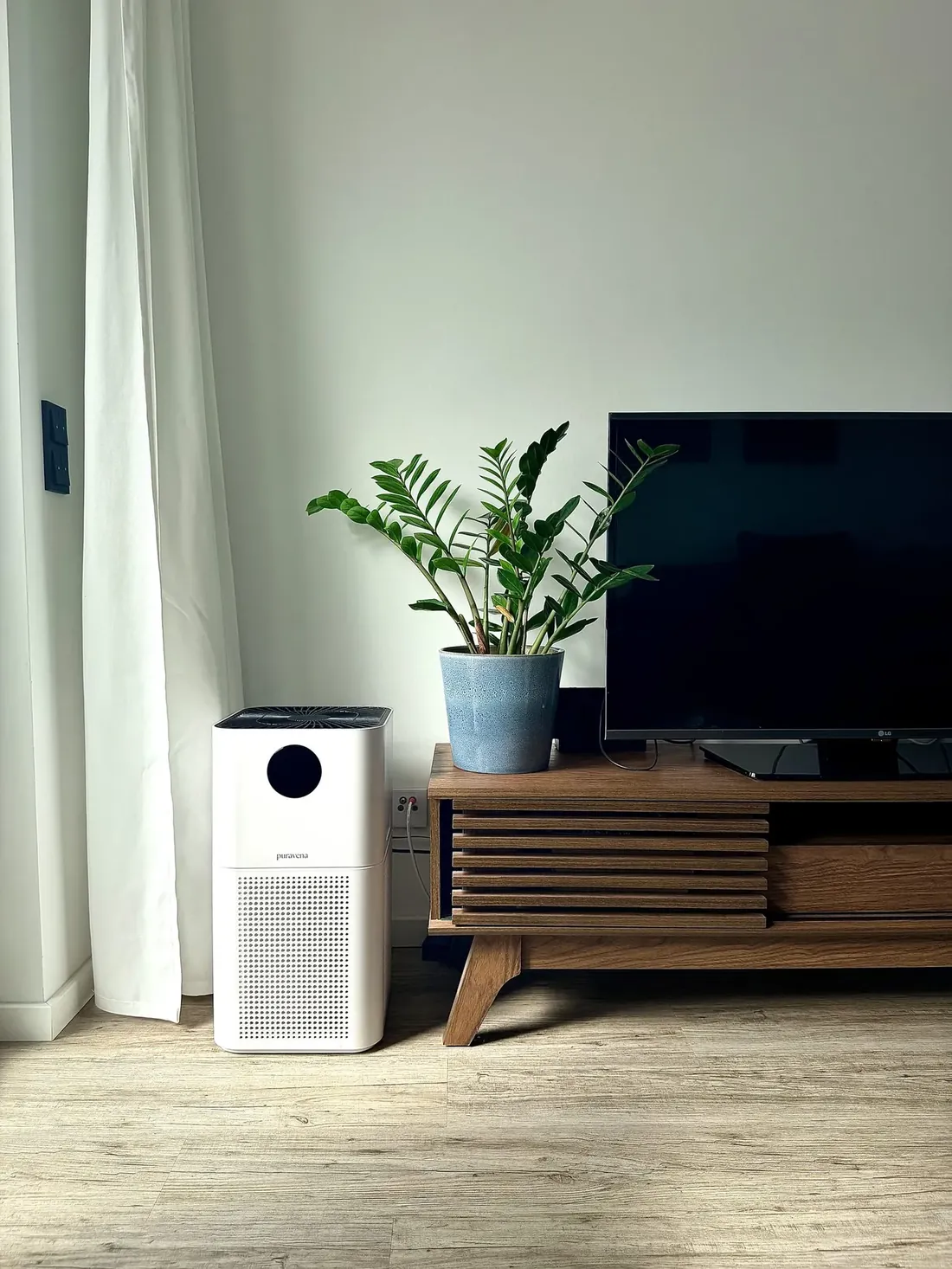 Luftreiniger Avelia 440 neben einem Lowboard mit Pflanze